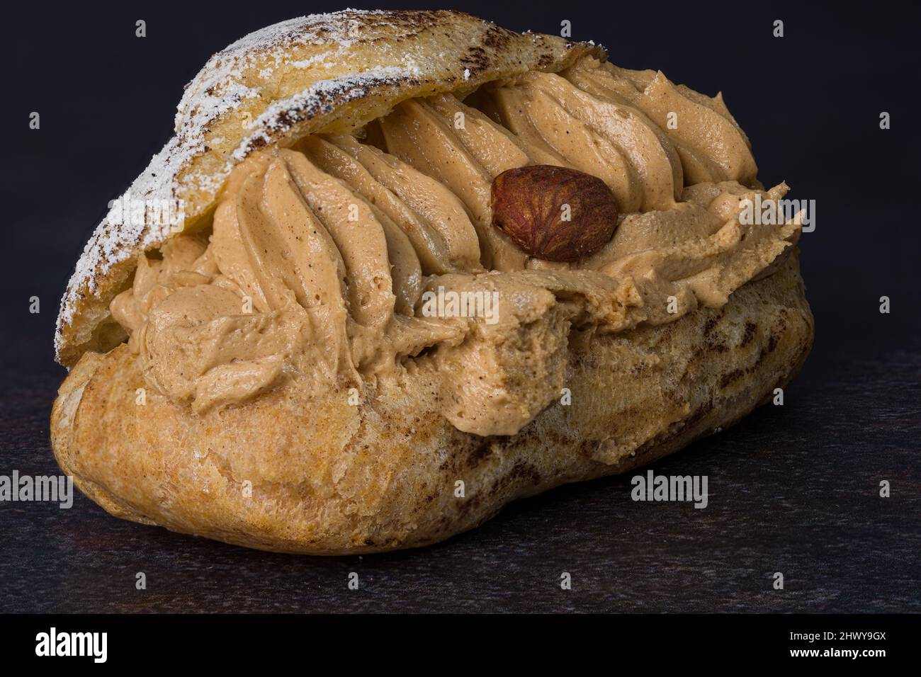 Fotografieren Sie auf einem schwarzen Hintergrund eines köstlichen Paris-Brest Stockfoto