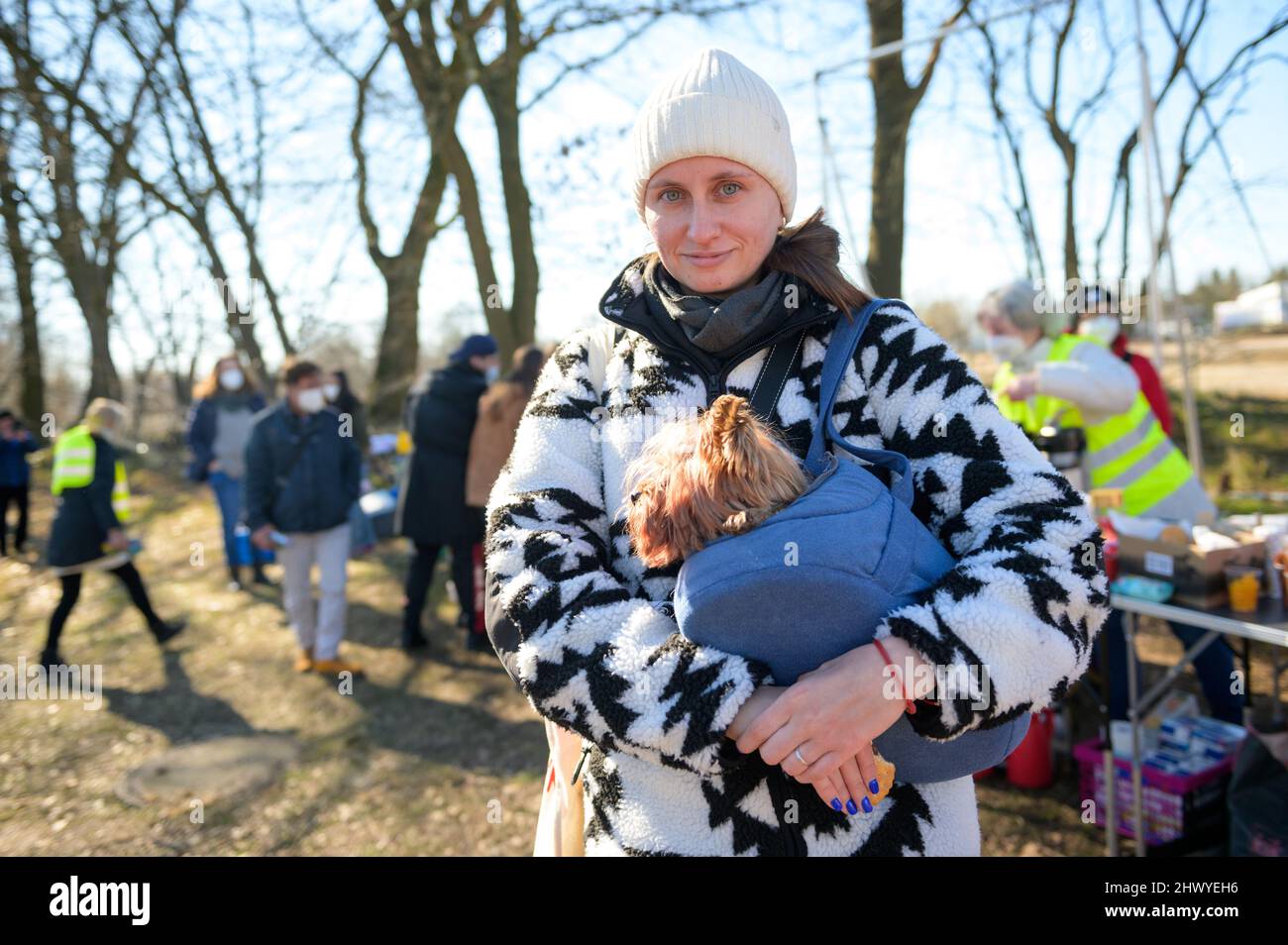 Hamburg, Deutschland. 08. März 2022. Kate Uvarova, eine Flüchtling aus der Ukraine, steht mit ihrem Hund Elsa in der Nähe des Zentralen Erstaufnahmezentrums (ZEA) in Rahlstedt. Ukrainische Flüchtlinge mit Haustieren sollen in Hamburg mit Tierpatenschaften unterstützt werden. Nach dem Gesetz ist es Personen mit Hunden und Katzen nicht erlaubt, in einer gemeinsamen Unterkunft untergebracht zu werden. Quelle: Jonas Walzberg/dpa/Alamy Live News Stockfoto