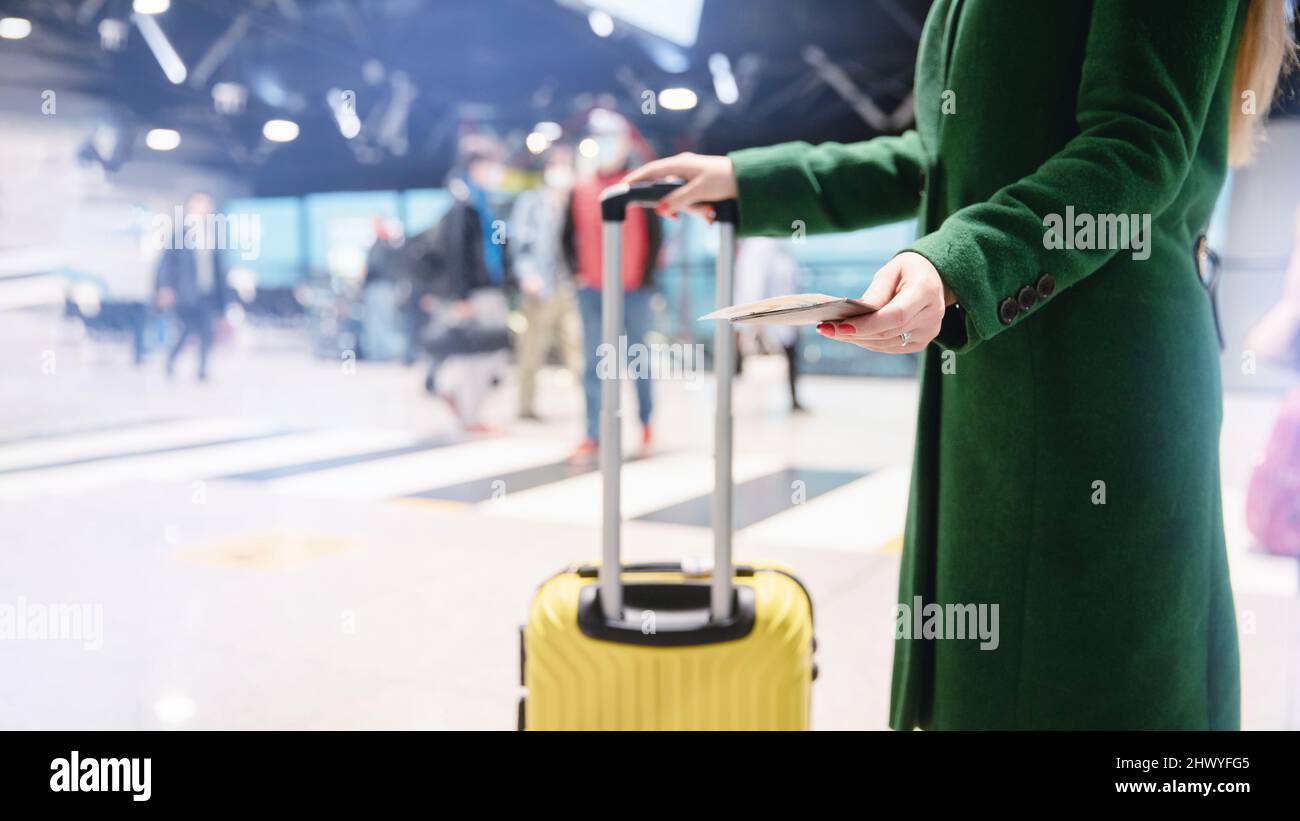 Gesichtslose Mädchen in grünem Mantel hält Pass mit Ticket und gelben  Koffer Flughafen. Flugreisekonzept im Herbst Stockfotografie - Alamy