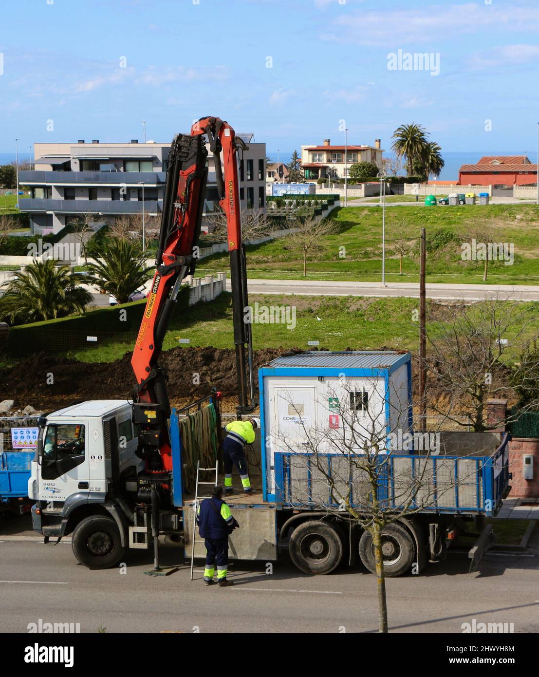 Vorbereitung eines LKW-Krans, der einen auf eine Baustelle in Cueto Santander Cantabria Spanien bringt Stockfoto