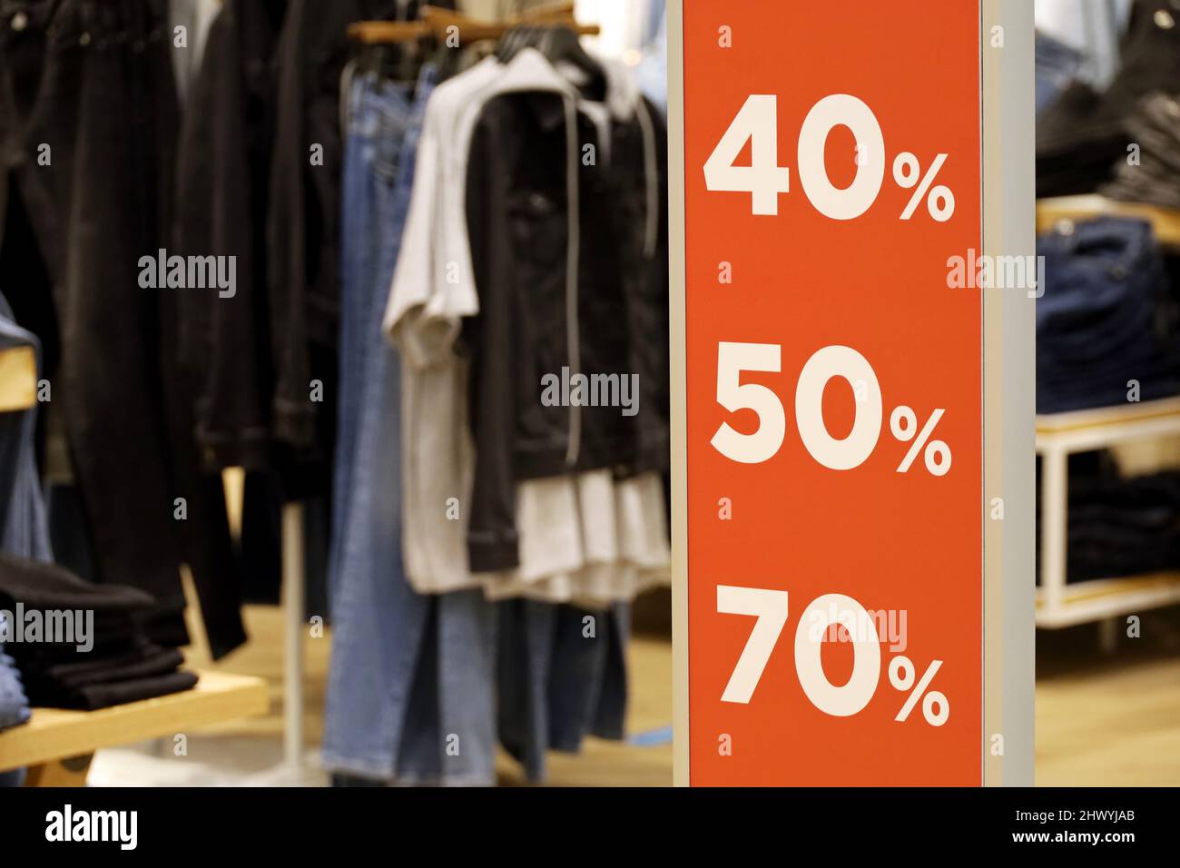 Verkaufsschild mit verschiedenen Rabatten in einem Bekleidungsgeschäft. Konzept des Einzelhandels und des Einkaufens Stockfoto