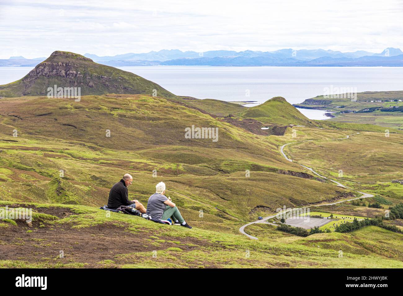 Ein Paar mittleren Alters genießt die Aussicht auf dem Quiraing Walk im Norden der Isle of Skye, Highland, Schottland, Großbritannien. Stockfoto