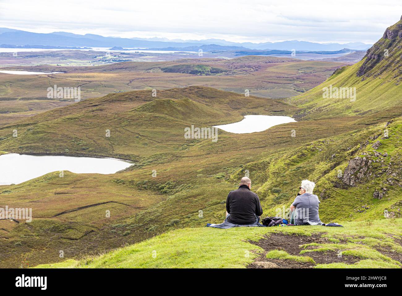 Ein Paar mittleren Alters genießt die Aussicht auf dem Quiraing Walk im Norden der Isle of Skye, Highland, Schottland, Großbritannien. Stockfoto