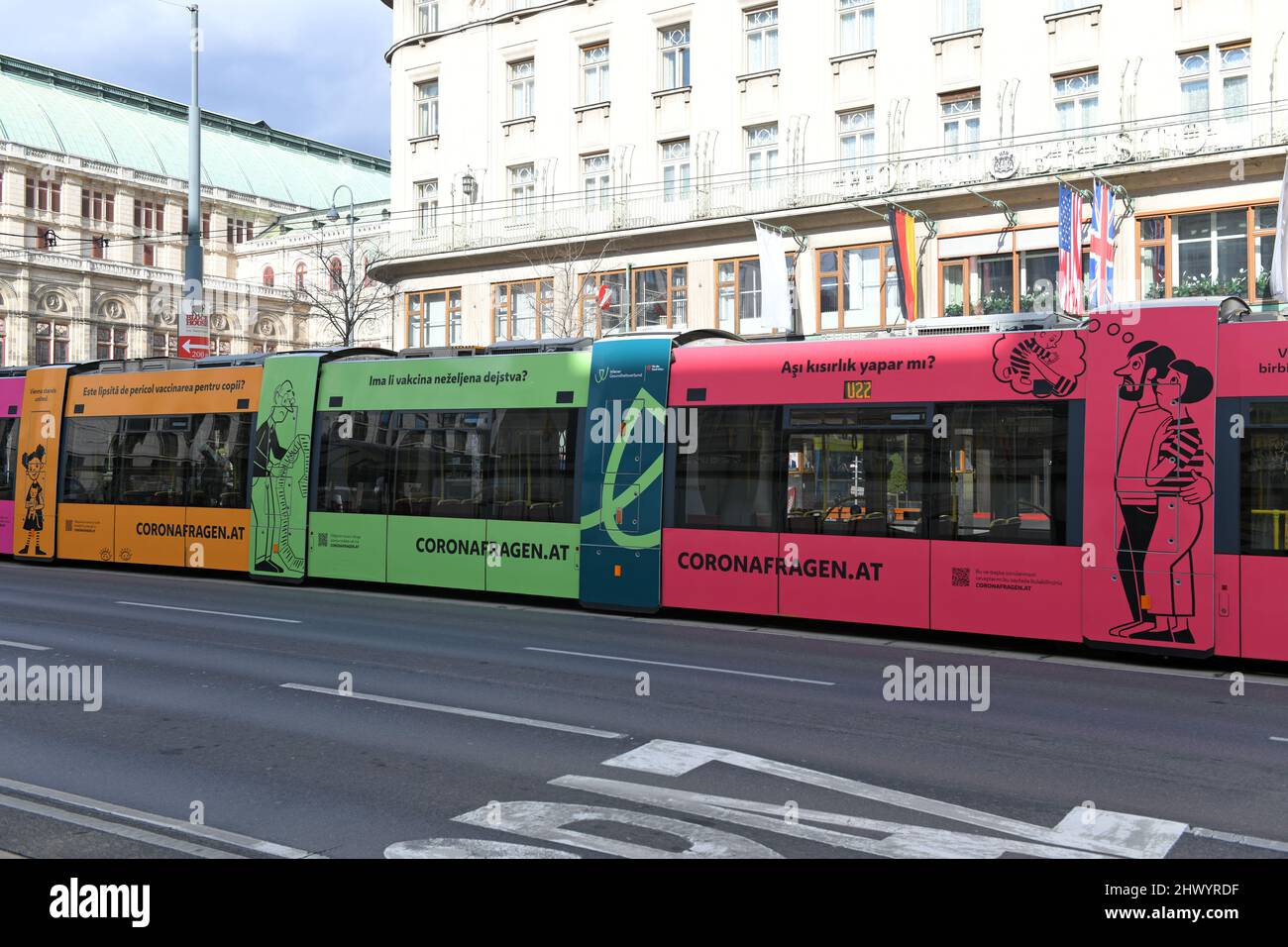 Bunte Straßenbahn in Wien mit mehrsprachiger Schrift zu Coronafragen, Österreich - Bunte Straßenbahn in Wien mit mehrsprachiger Inschrift auf Corona Stockfoto