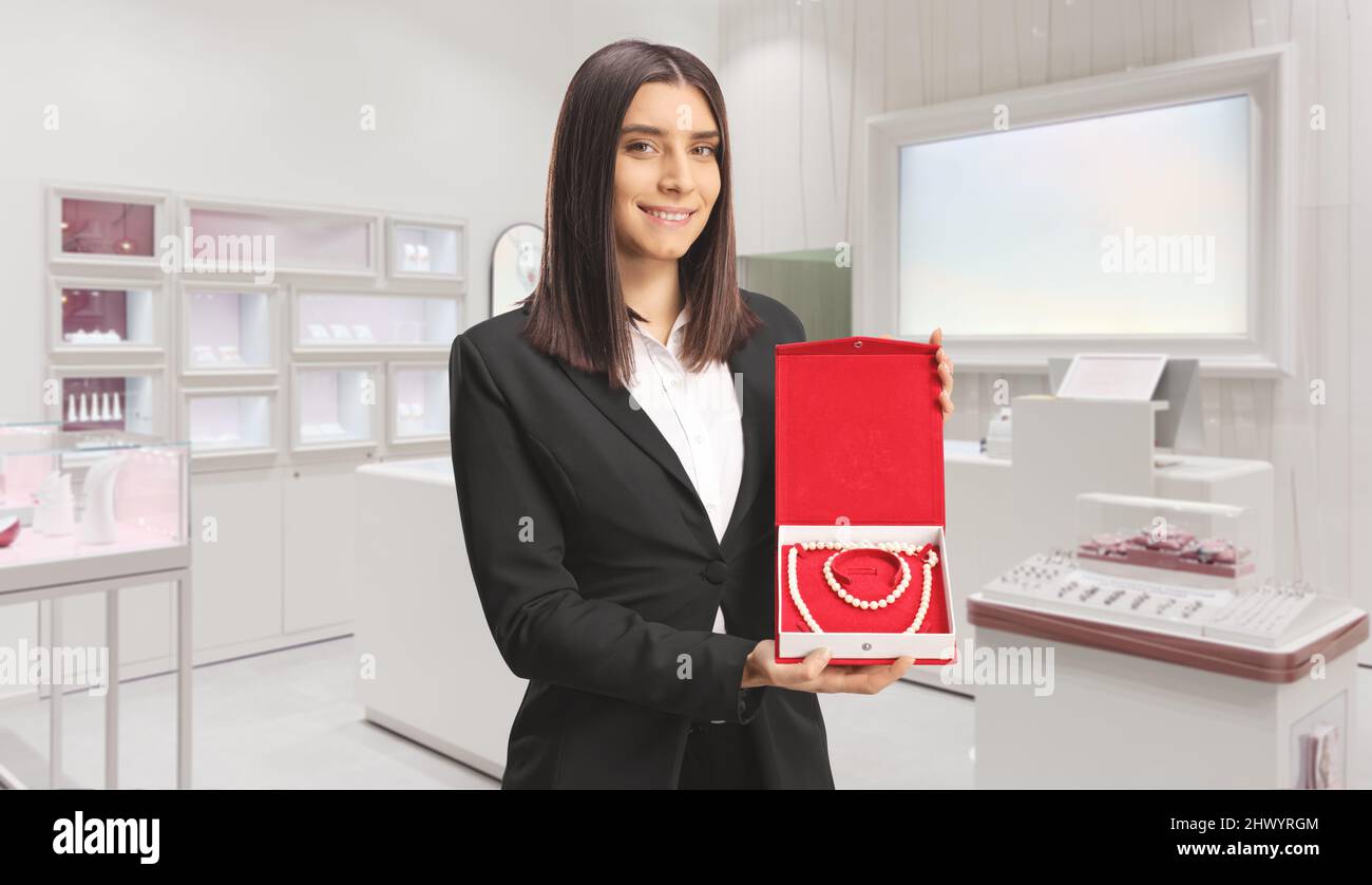 Schmuckverkäuferin mit Perlenkette und Armband in einer Schachtel in einem Geschäft Stockfoto