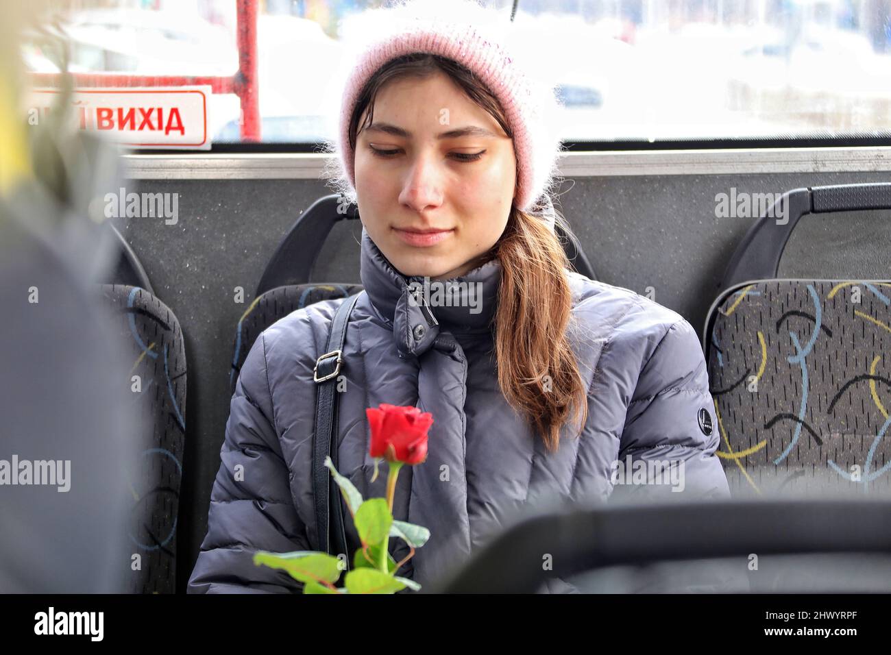ODESA, UKRAINE - 8. MÄRZ 2022 - Eine junge Frau hält eine Rose, die im Rahmen einer traditionellen Aktion präsentiert wird, wenn Frauen aus Odesa Blumen und kostenlose Fahrten erhalten Stockfoto