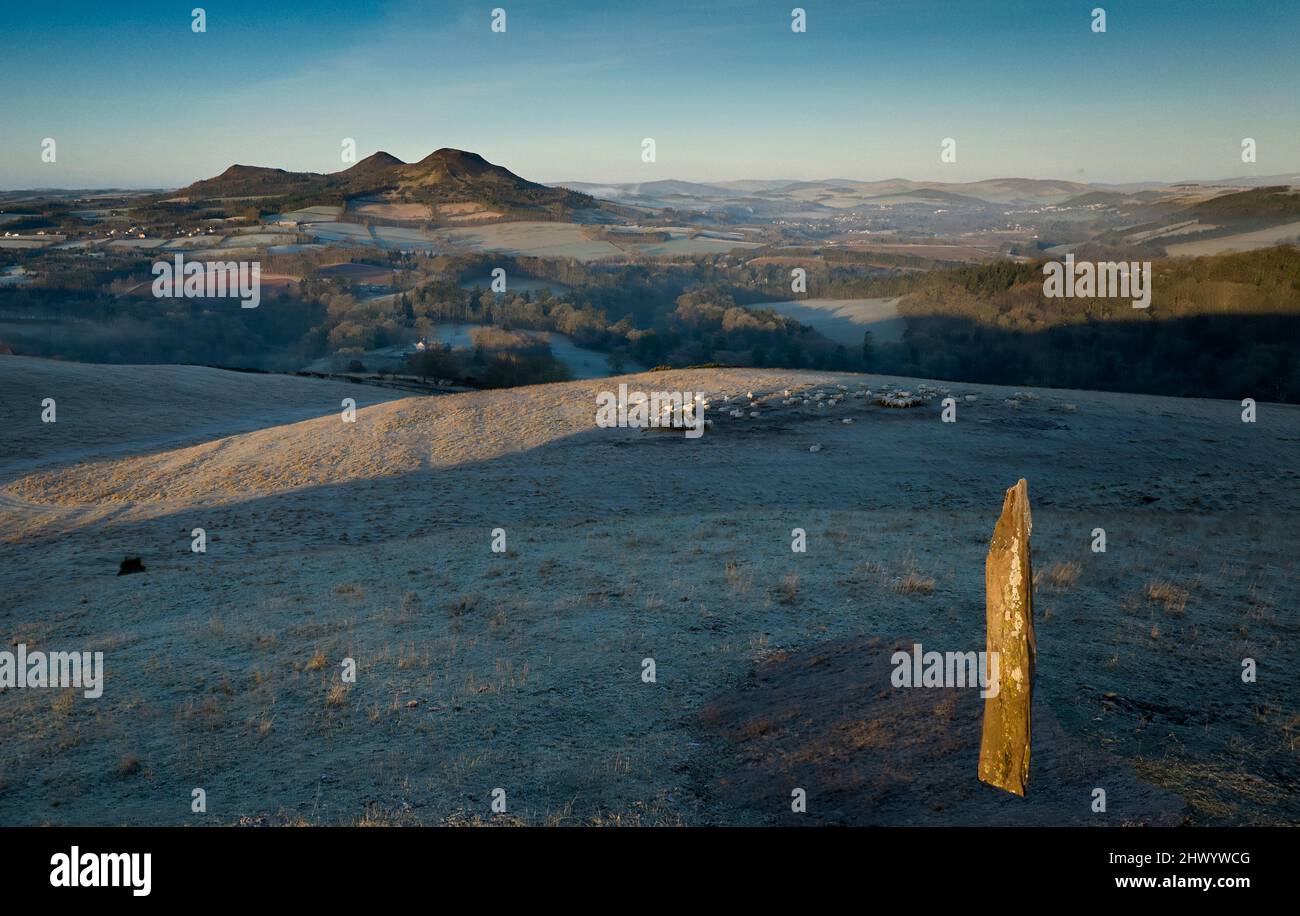 Blick auf den Fluss Tweed und die Eildon Hills von oben Scotts Blick mit einem stehenden Stein, der an einem frostigen Morgen das Licht der aufgehenden Sonne erhellte. Stockfoto