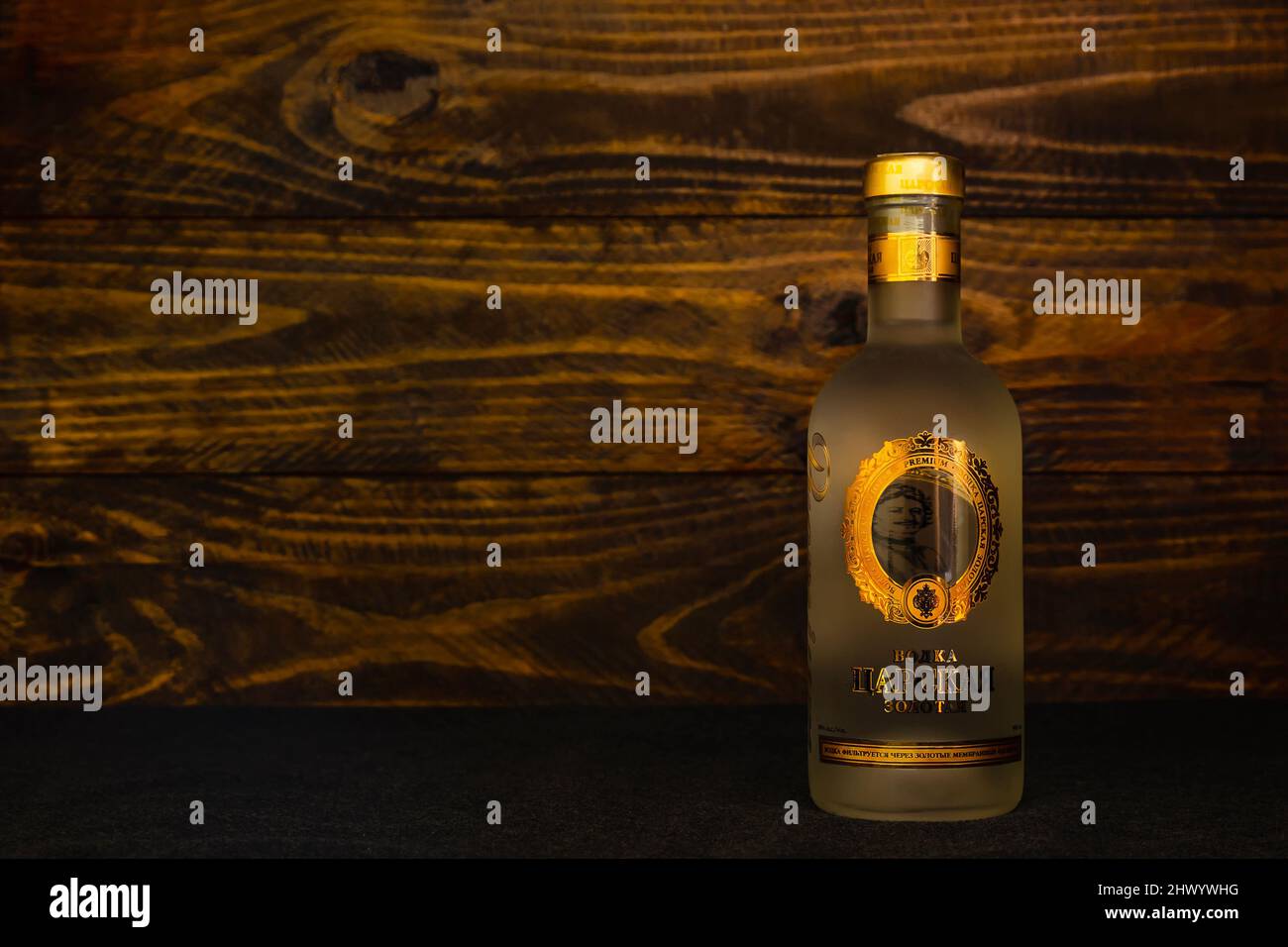 Eine Flasche russischen Wodka Tsarskaya Zolotaya auf dunklem Holzboden. Dieser Premium-Wodka hat sowohl in Russland als auch in der abr Popularität und viele Auszeichnungen gewonnen Stockfoto