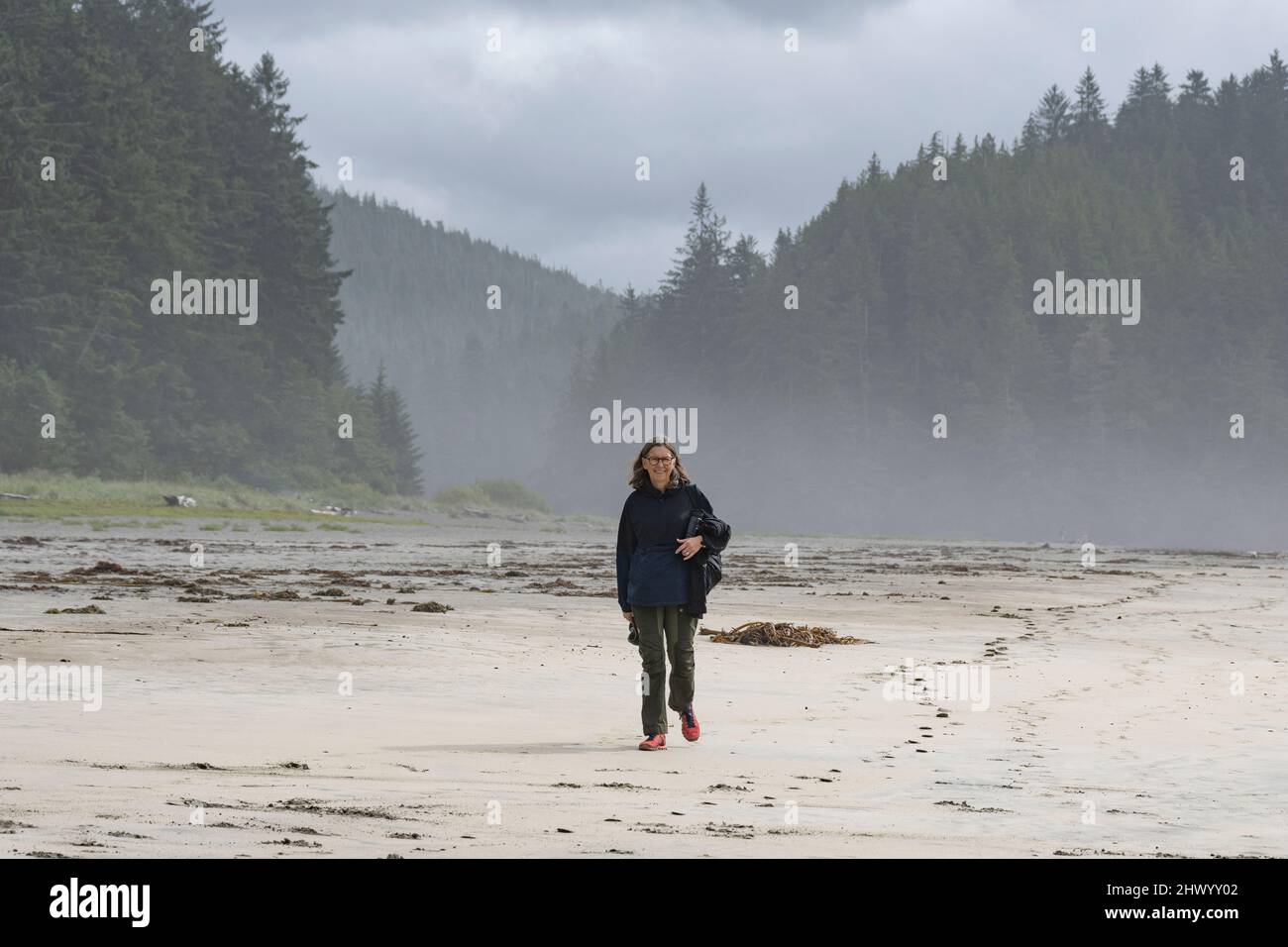 Weibliche Touristen, die am Strand im Cape Scott Provincial Park, San Josef Bay, Mount Waddington, Vancouver Island, British Columbia, Kanada Stockfoto