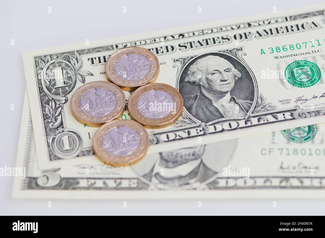 Vier britische Pfund-Münzen auf US-Dollar-Banknoten Stockfoto