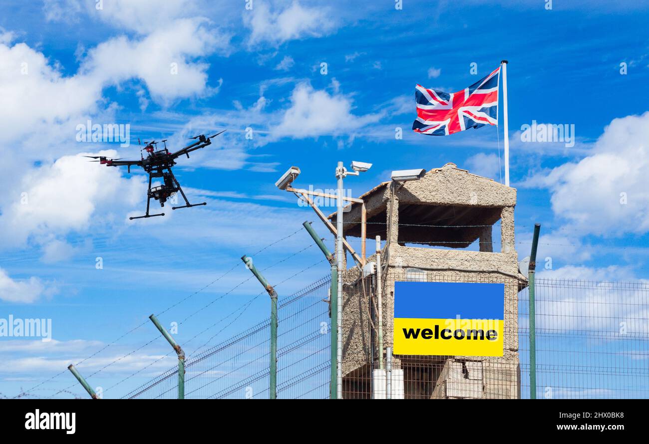Stacheldrahtzaun und Wachturm mit Empfang auf der Flagge der Ukraine. Britische Einwanderung, Visapolitik, Ukraine, Russland Konflikt Flüchtling, Brexit, EU-Grenze Stockfoto