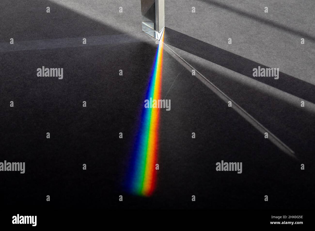 Lichtstrahlen, die ins Prisma eindringen und Schatten und Regenbogenbrechung erzeugen Stockfoto