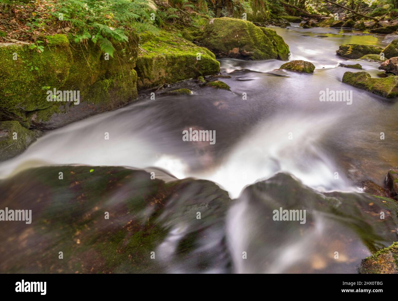 Abstrakter Blick auf Wasserkaskaden mit Bewegungsunschärfen bei einer Reihe spektakulärer Kaskaden und Wasserfälle entlang eines Abschnitts des Flusses Fowey, einer beliebten Tour Stockfoto