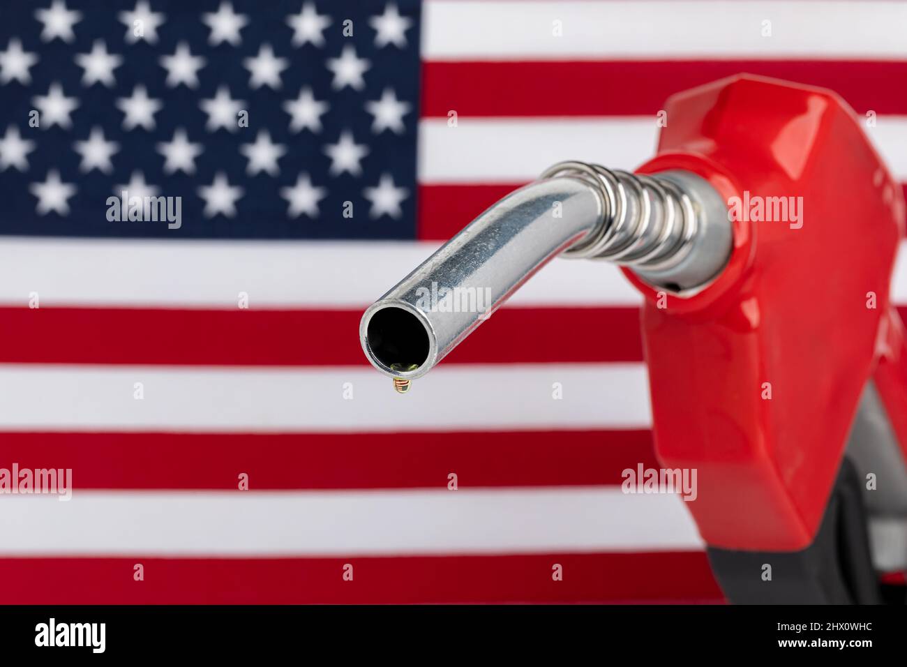 Gas tropft von der Kraftstoffdüse mit amerikanischer Flagge. Benzinknappheit, Preis und Ethanolkonzept. Stockfoto