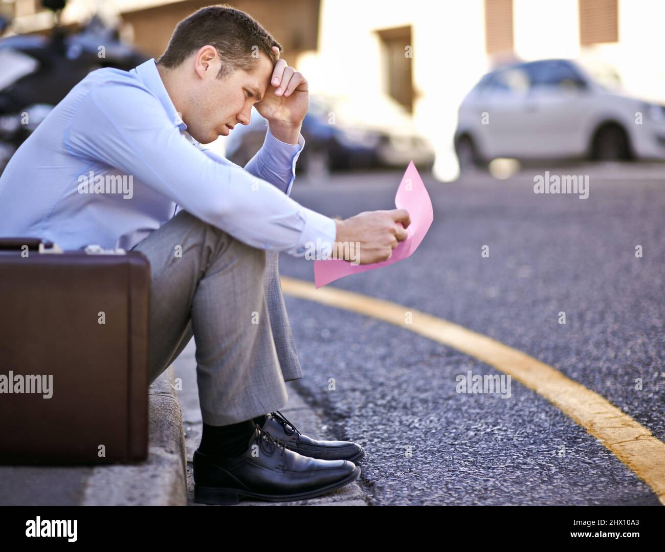 Ich hätte nie gedacht, dass mir das passieren würde. Ein Geschäftsmann, der einen rosafarbenen Slip hält, um seine Beschäftigung zu beenden. Stockfoto