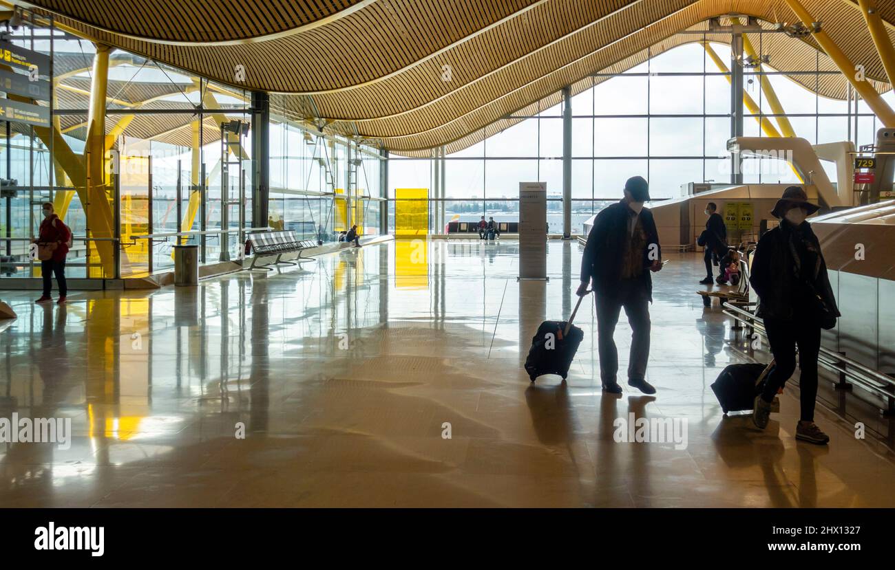Passagiere in Gesichtsmasken mit Gepäck am Flughafen Madrid-Barajas, MAD, Spanien Stockfoto