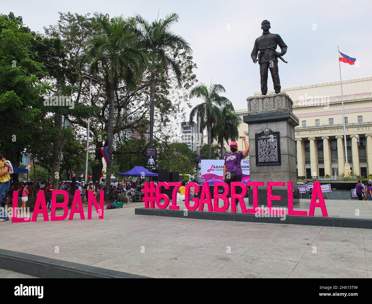 Manila, Philippinen. 08. März 2022. Ein Protestler hebt eine Faust hinter der Statue des philippinischen Freiheitskämpfers Andres Bonifacio während einer Demonstration in Manila. GABRIELA, eine nationale Allianz philippinischer Frauen, veranstaltete zusammen mit anderen Frauengruppen-Organisationen einen protestmarsch in manila im Rahmen des Internationalen Frauentags. Zu den Anliegen der militanten Gruppe gehörten der steigende Treibstoffpreis, Armut, Landstreitigkeiten, gute Regierungsführung bei diesen kommenden nationalen und lokalen Wahlen und protestierte gegen die Ungerechtigkeiten gegen Frauen, insbesondere indigene Frauen. Kredit: SOPA Images Limited/Alamy Live Nachrichten Stockfoto