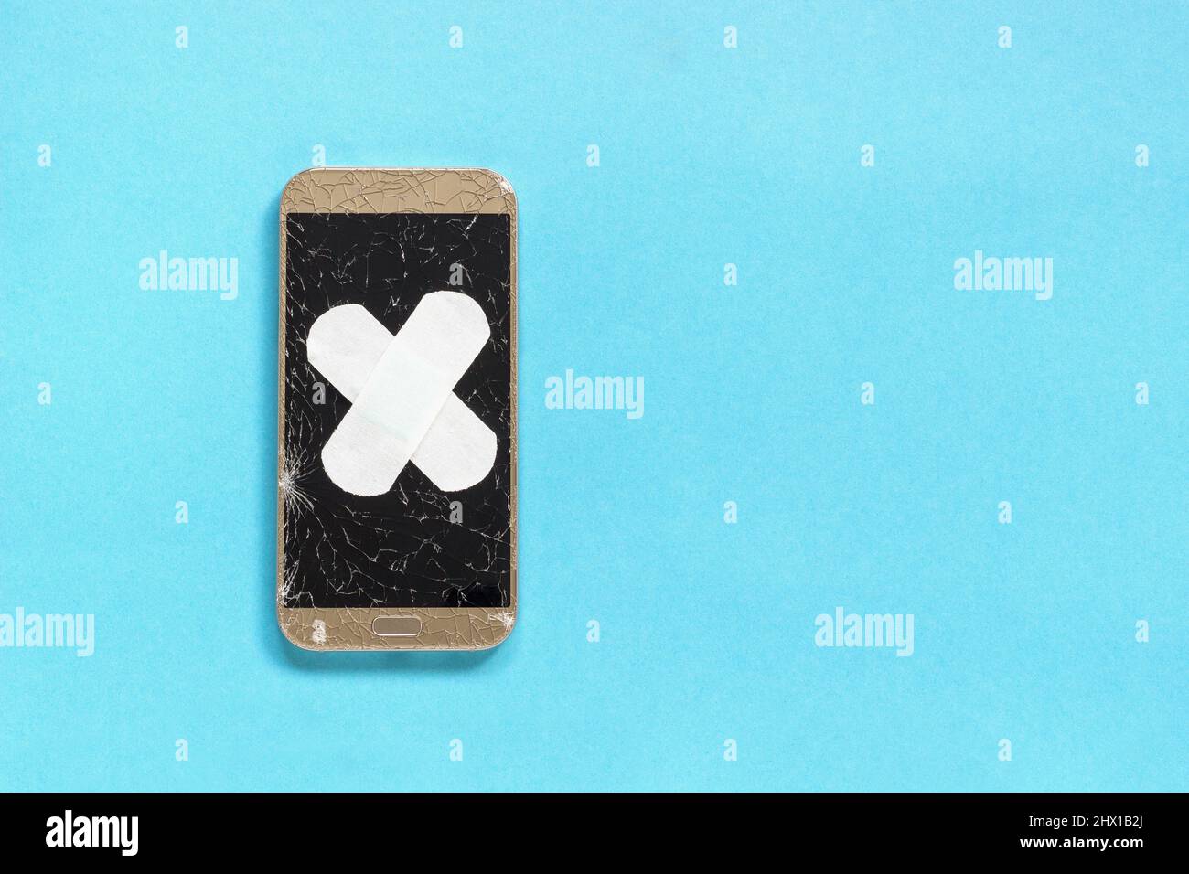 Defektes Handy mit geknacktem Bildschirm ist Band-Aid medizinischen Putz auf blauem Hintergrund Flat Lay, Konzept abgedeckt Stockfoto
