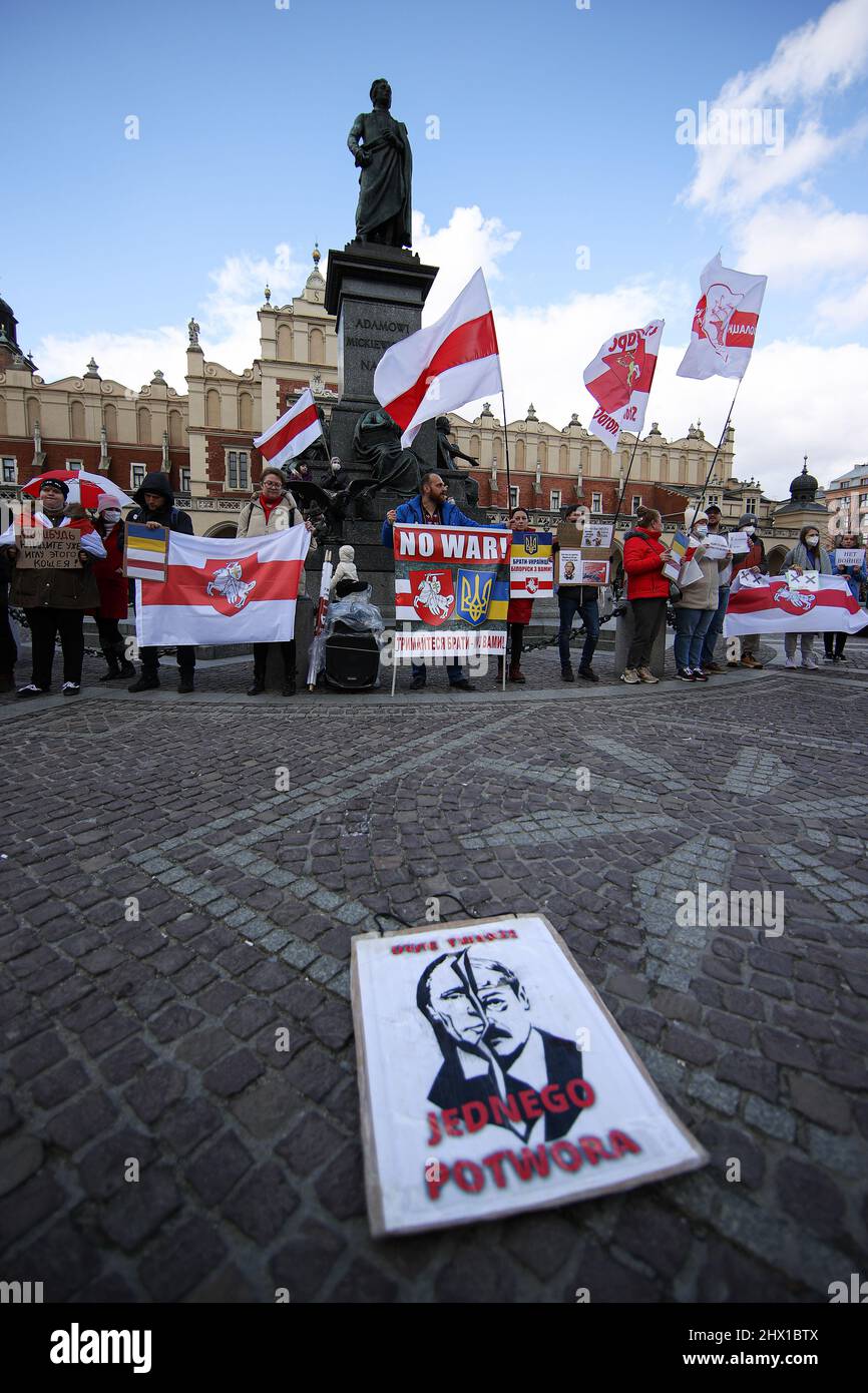 Krakau, Polen. 27.. Februar 2022. Eine Illustration eines Putin-Hitler-Hybryds, der "zwei Gesichter - ein Monster" unterzeichnete, mit Demonstranten, die sich während der Demonstration im Hintergrund versammelten. Nach der russischen Aggression auf die Ukraine im Februar dieses Jahres protestieren Menschen auf der ganzen Welt, um Unterstützung für das angegriffene Land zu zeigen. Eine von ihnen war eine von den in Krakau lebenden Weißrussen organisierte Demonstration, die die Freiheit der Ukraine und Weißrussland forderte. (Foto: Vito Corleone/SOPA Images/Sipa USA) Quelle: SIPA USA/Alamy Live News Stockfoto
