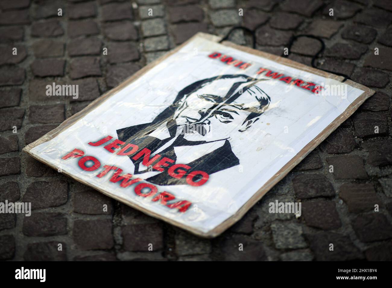 Krakau, Polen. 27.. Februar 2022. Eine Illustration, die die Hälfte von Putins und Hitlers Gesicht zeigt, und ein Slogan 'Two Faces - One Monster', der während der Demonstration auf dem Bürgersteig liegt. Nach der russischen Aggression auf die Ukraine im Februar dieses Jahres protestieren Menschen auf der ganzen Welt, um Unterstützung für das angegriffene Land zu zeigen. Eine von ihnen war eine von den in Krakau lebenden Weißrussen organisierte Demonstration, die die Freiheit der Ukraine und Weißrussland forderte. (Foto: Vito Corleone/SOPA Images/Sipa USA) Quelle: SIPA USA/Alamy Live News Stockfoto