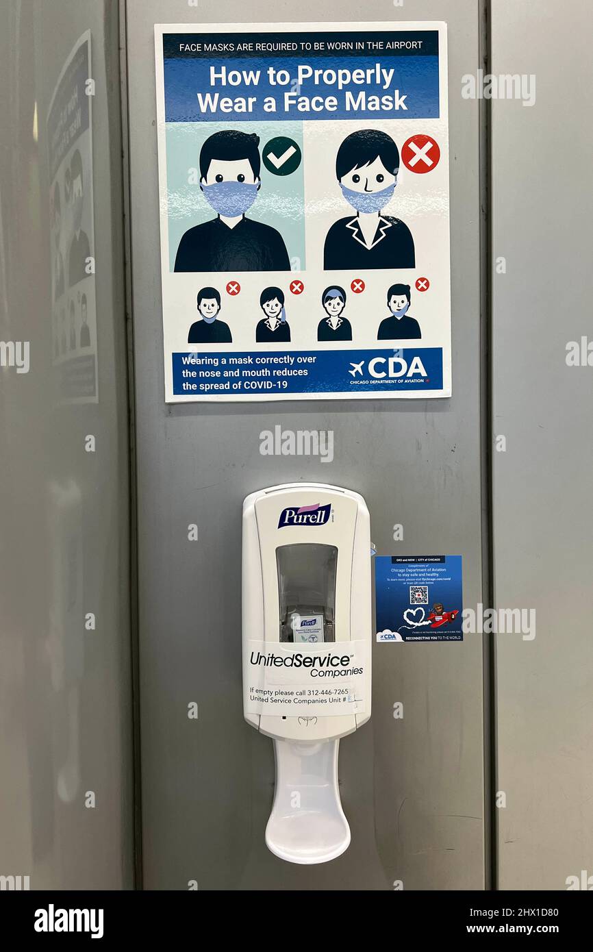 Ein Coronavirus-COVID-19-Beratungsschild für Gesichtsmasken, gesponsert vom Chicago Department of Aviation und Handdesinfektionsmittel in Terminal 3 am O'Hare International Airport (ORD), Sonntag, 6. März 2022, in Chicago. Stockfoto