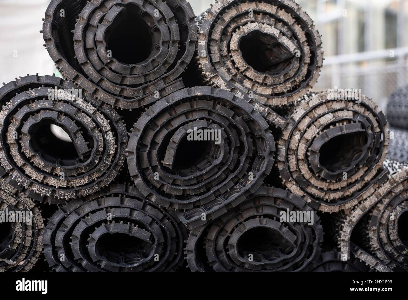 Nahaufnahme von gestapelten schwarzen Gummimatten, die zur Lagerung  aufgerollt sind Stockfotografie - Alamy