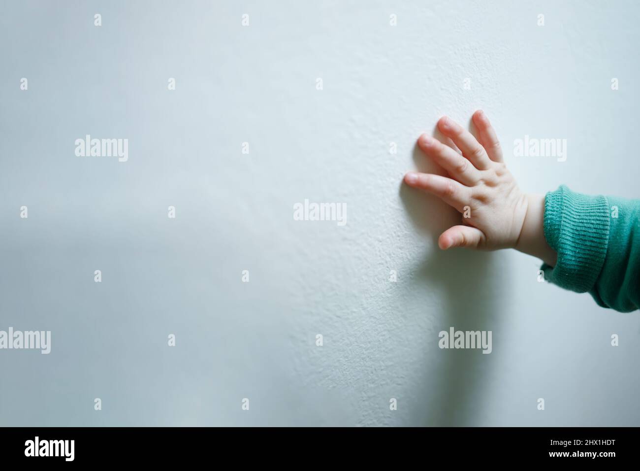 Eine Kinderhand an einer weißen Wand, Konzept der humanitären Hilfe Stockfoto