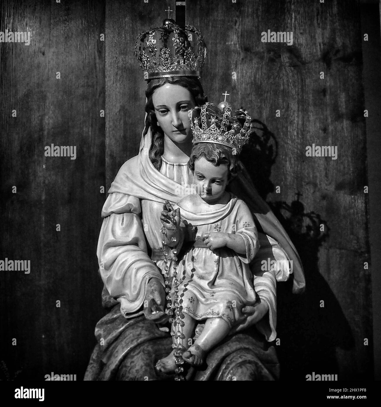 Jungfrau Maria mit der Jesuskind-Statue in einer katholischen Kirche - Schwarz-Weiß-religiöse Kunstfotografie Stockfoto