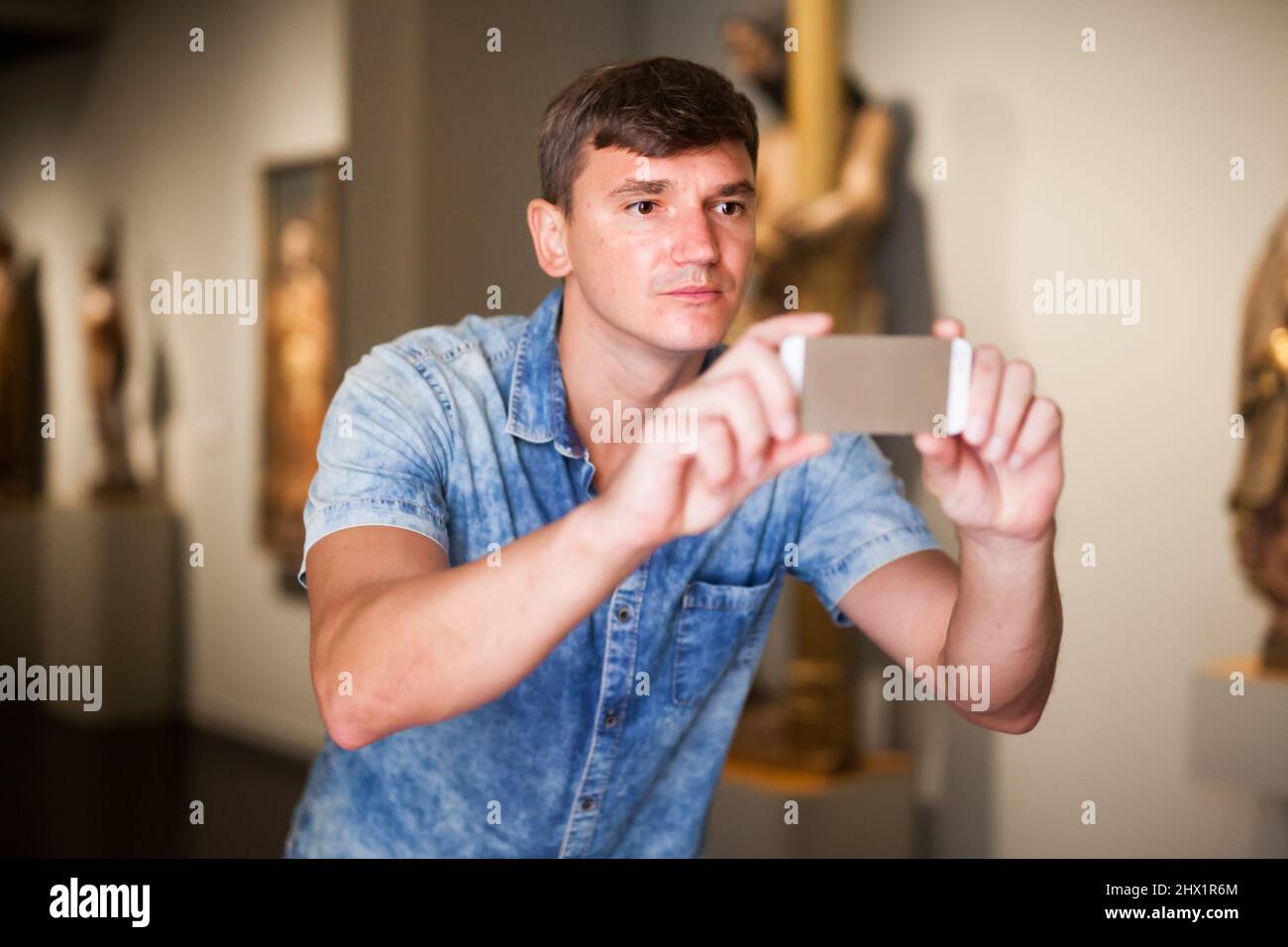 Mann, der im Museum Fotos am Telefon gemacht hat Stockfoto