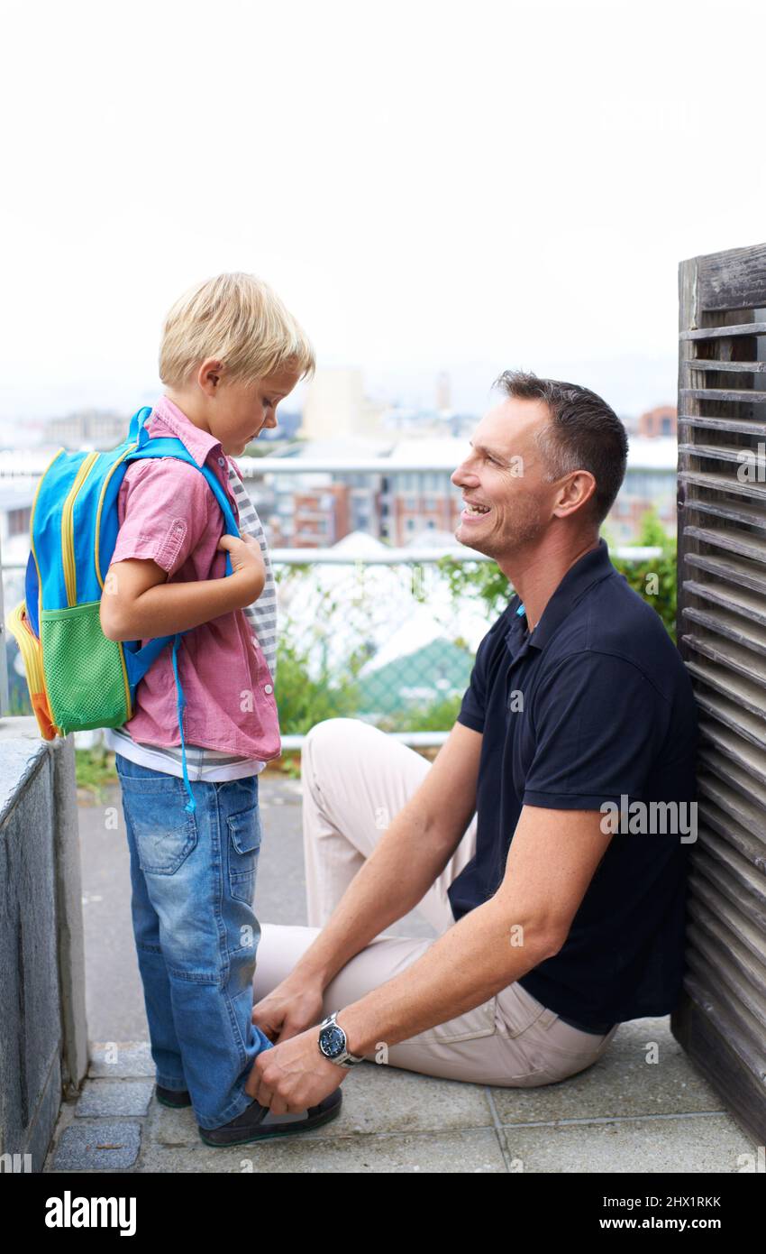 Großer Tag für meine Söhne. Ein Vater hilft seinem Sohn, sich auf die Schule vorzubereiten. Stockfoto