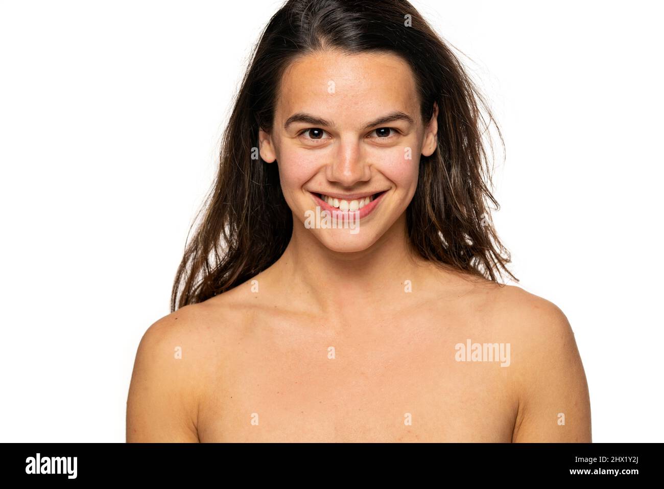 Porträt einer jungen Frau, die ohne Make-up lächelt, auf weißem Hintergrund Stockfoto