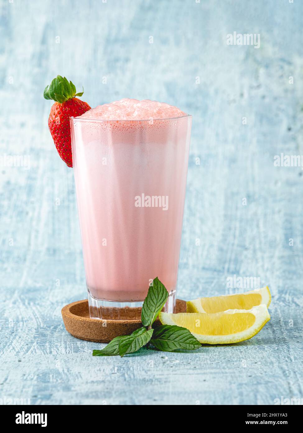 Erdbeer- und Zitronenmilchshake oder Smoothie auf blauem Stein-Hintergrund Stockfoto