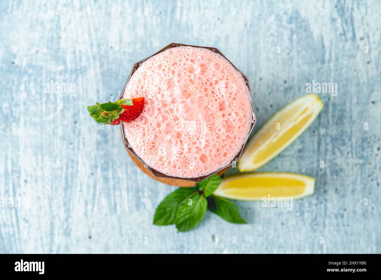 Erdbeer- und Zitronenmilchshake oder Smoothie auf blauem Stein-Hintergrund Stockfoto