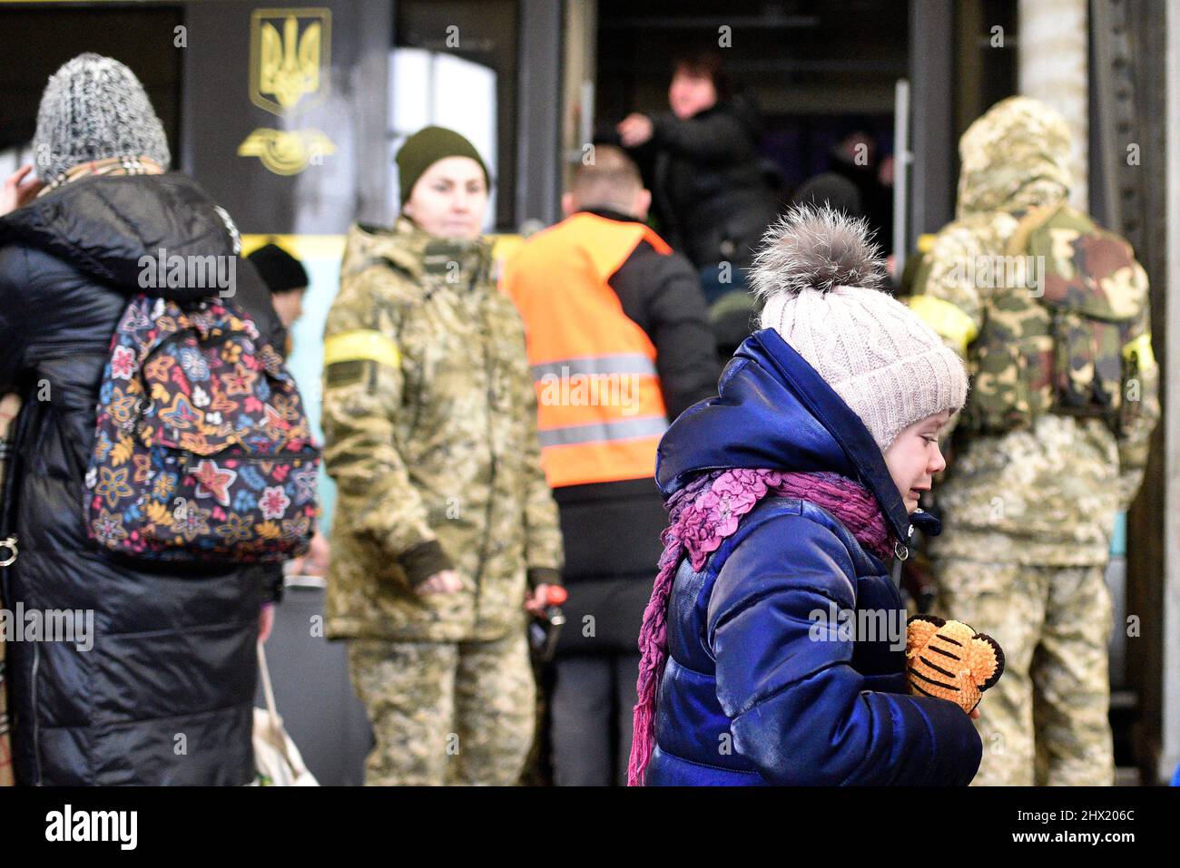 LVIV, UKRAINE - 28. FEBRUAR 2022 - Ein Mädchen, das einen Spielzeug-Tiger hält, schreit am Bahnhof von Lviv, als Flüchtlinge vor Feindseligkeiten an Bord des Evakuierungsfahrzeugs gehen Stockfoto