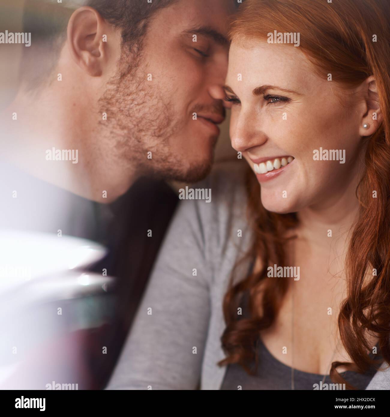 Flüstert süße Dinge. Aufnahme eines liebevollen jungen Paares an einem Date. Stockfoto