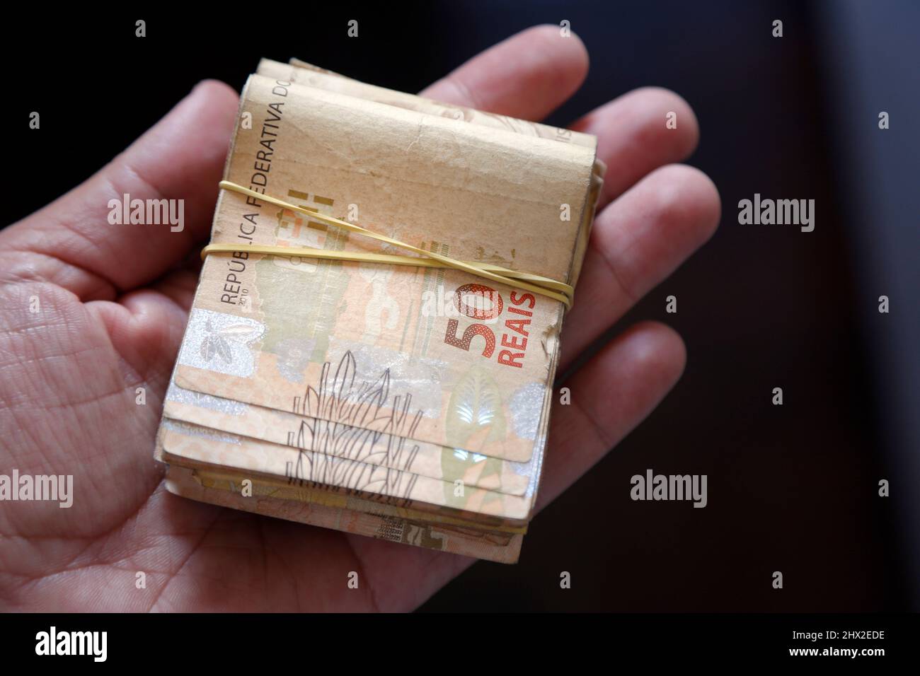 Brasilien Geld gestapelt und gruppiert - mehrere brasilianische reale Banknoten in der Hand Stockfoto