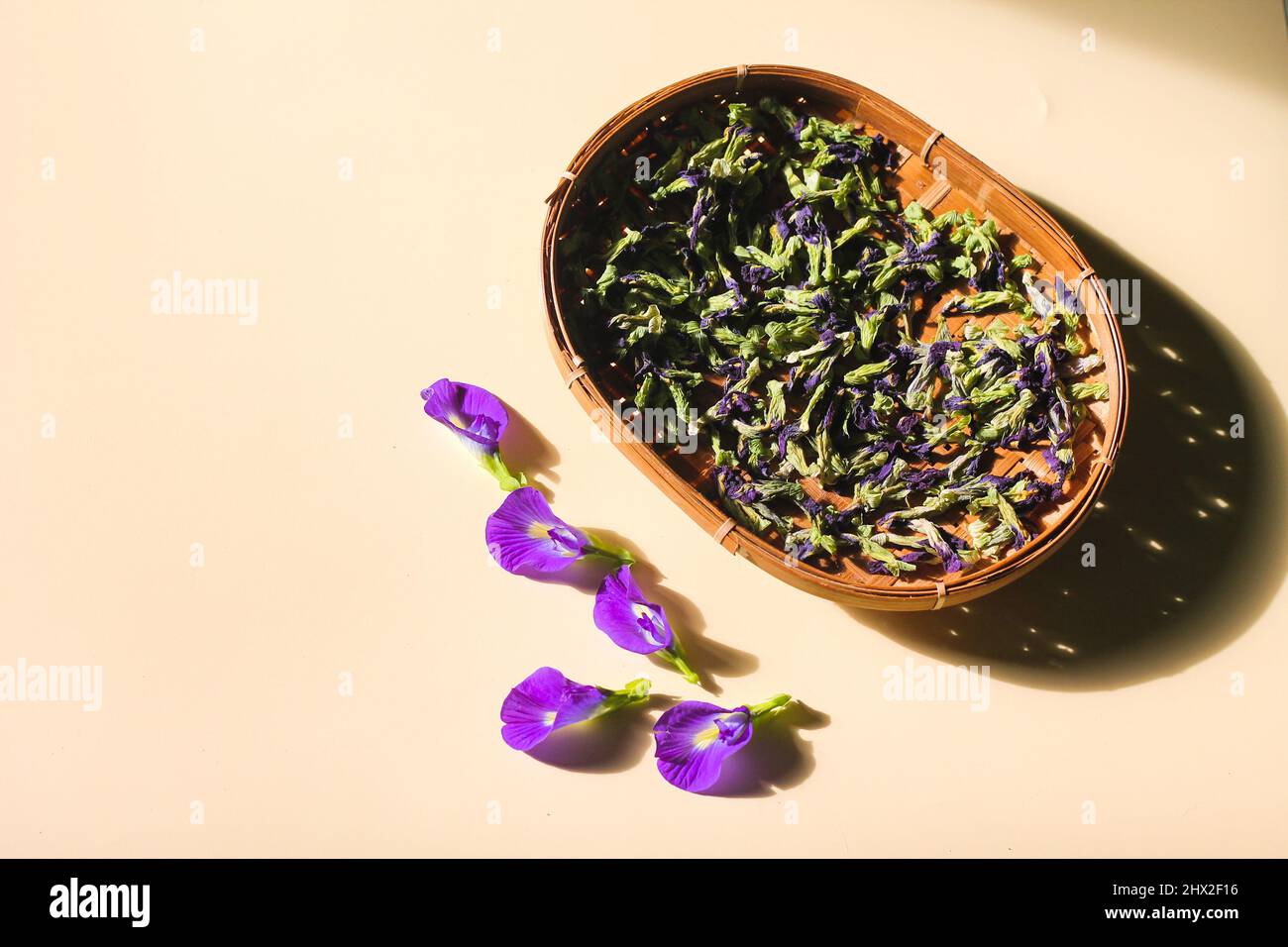 Bona Telang Kering oder getrocknete Butterfly Pea Blumen auf gewebtem Bambusblech. Isolierter Hintergrund. Stockfoto