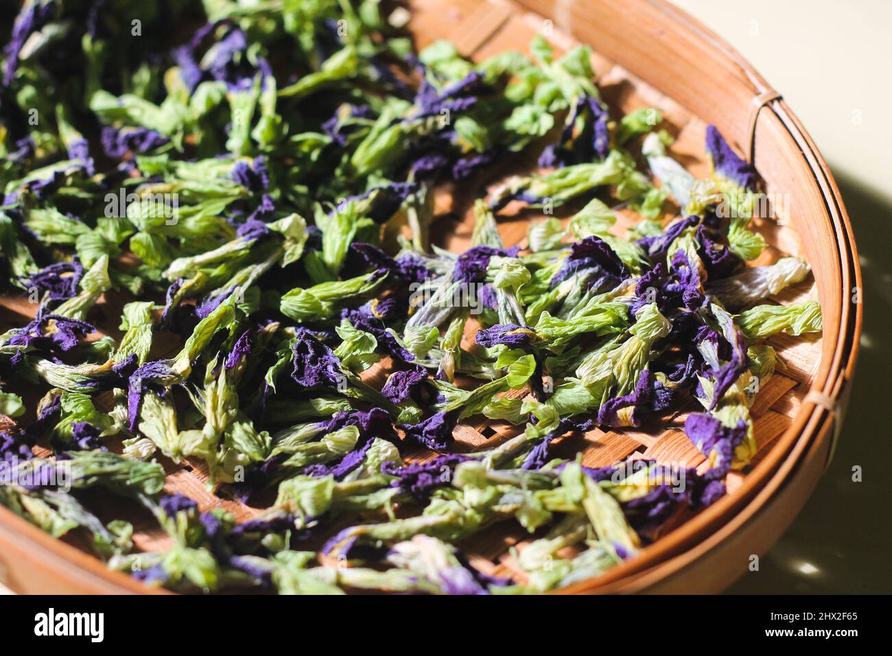Bona Telang Kering oder getrocknete Butterfly Pea Blumen auf gewebtem Bambusblech. Isolierter Hintergrund. Stockfoto