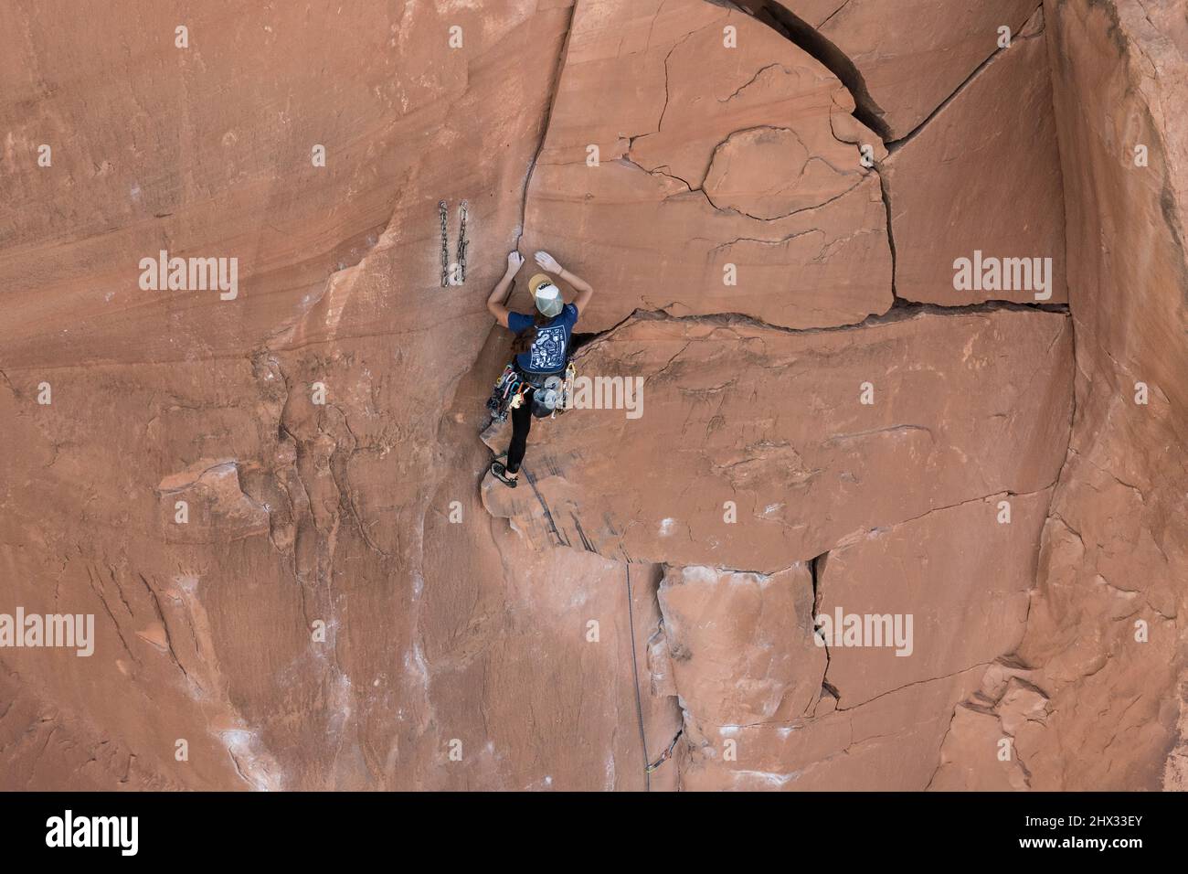 Eine Bleibergsteigerin erreicht die Spitze der Route, die Flocken of Wrath genannt wird, an der Wall Street in der Nähe von Moab, Utah. Stockfoto