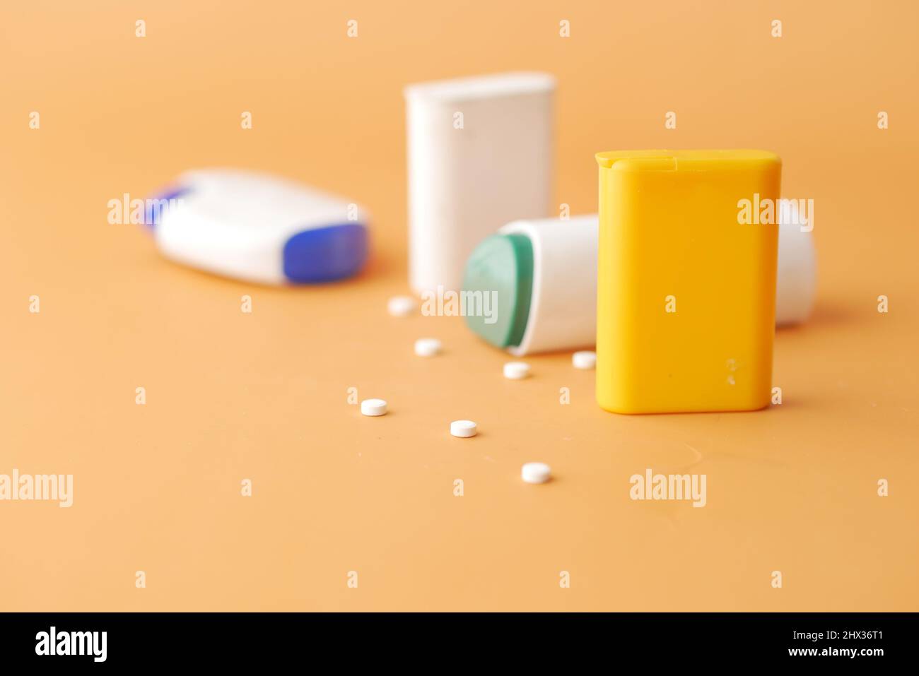 Künstliche Süßstoffbehälter auf orangefarbenem Hintergrund Stockfoto