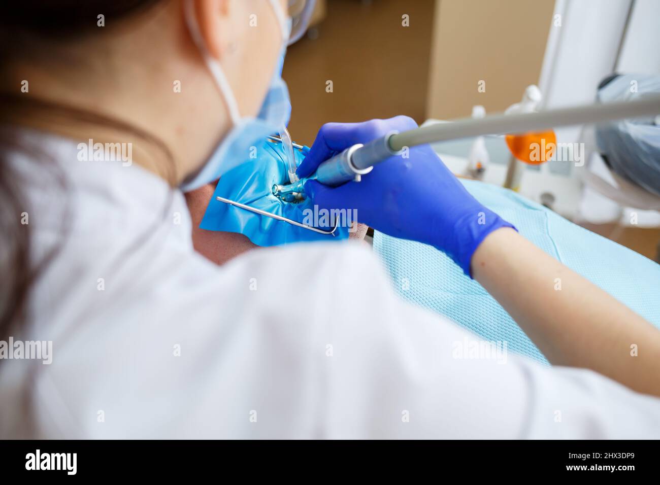 Ein Zahnarzt behandelt einen männlichen Patienten mit zahnmedizinischen Instrumenten. Der Zahnarzt untersucht die Zähne der Patienten in der Zahnklinik. Selektiver Fokus Stockfoto