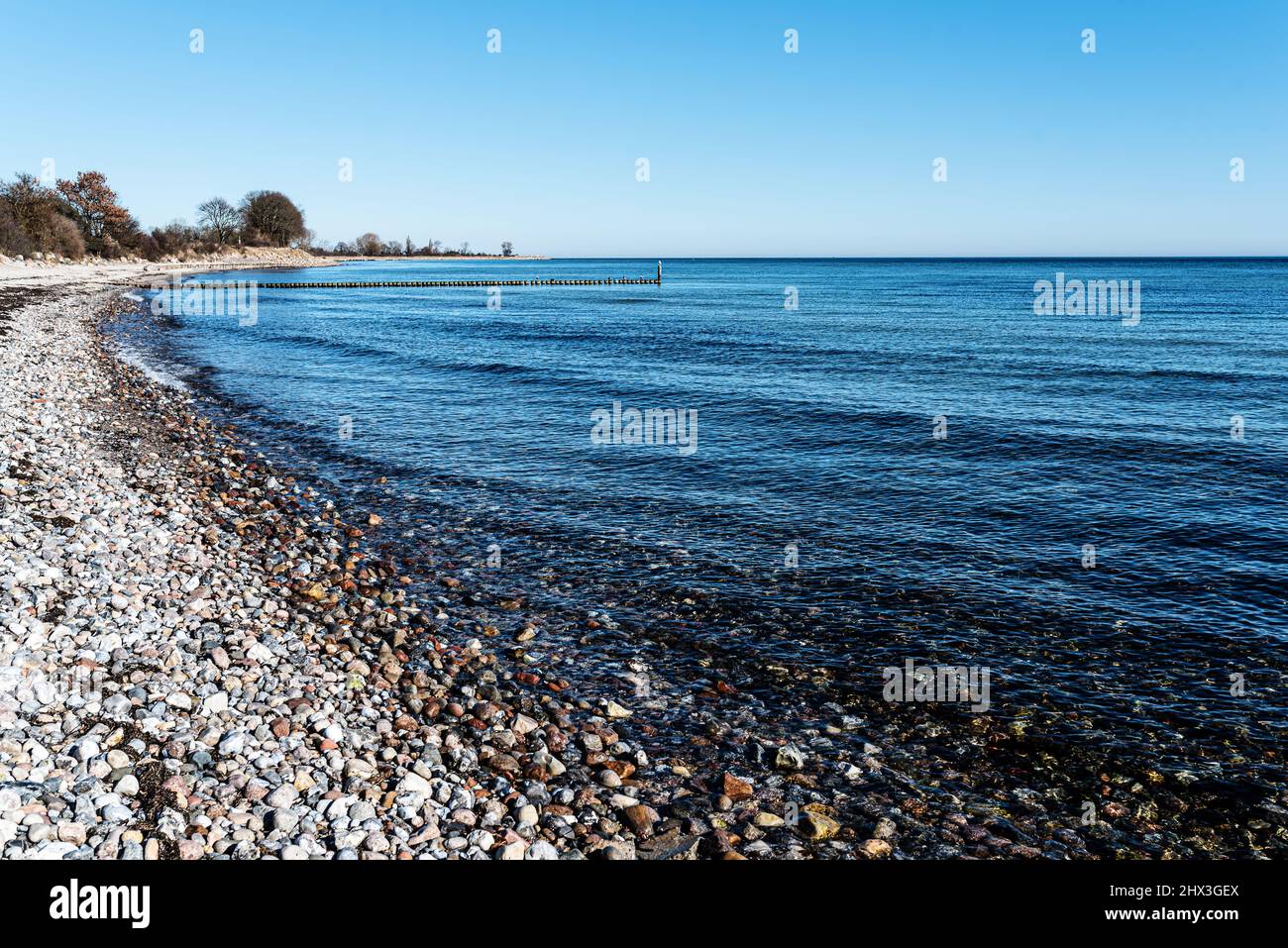 Kiesstrand an der ostsee gegen klaren blauen Himmel Stockfoto