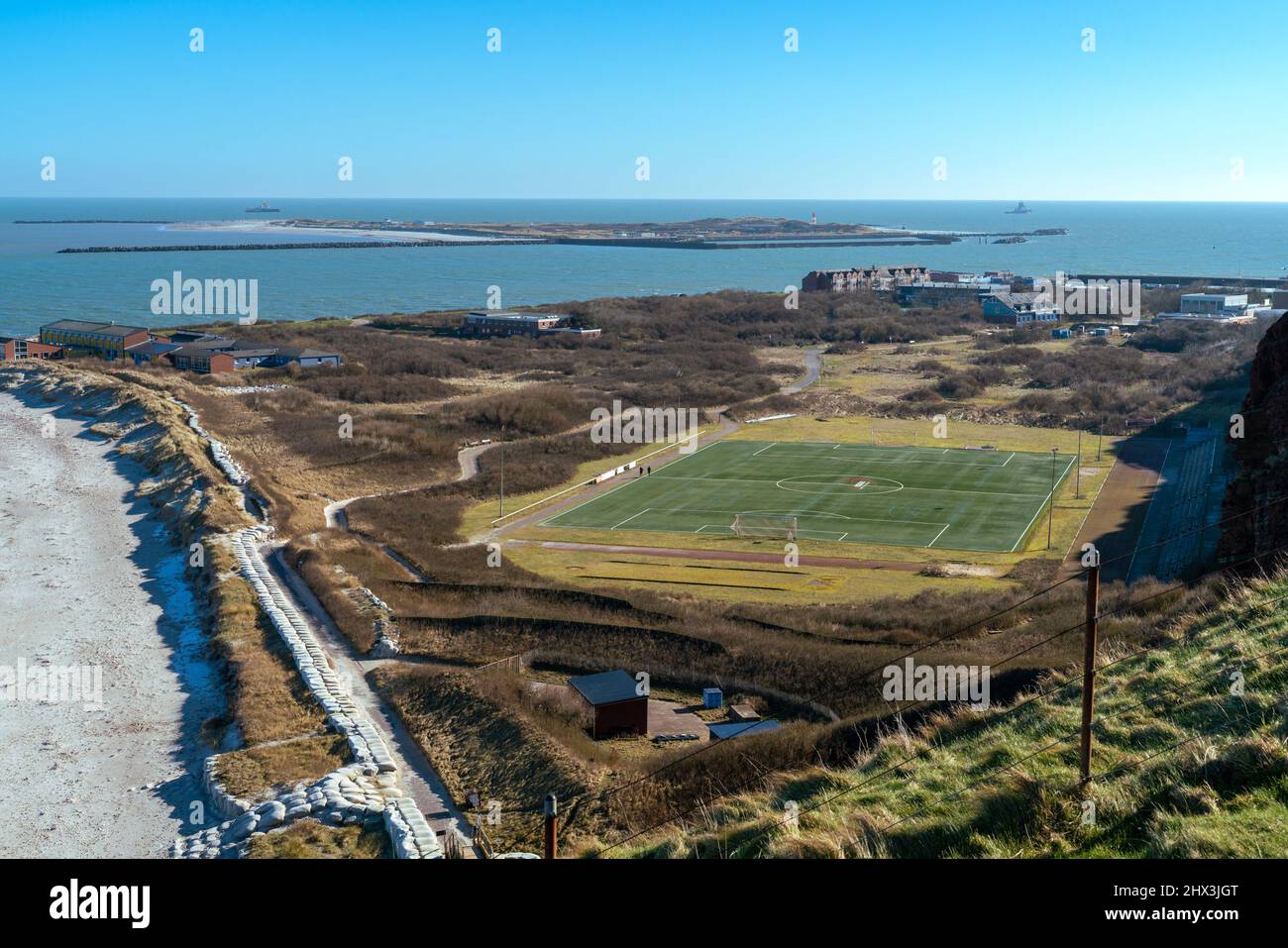 Fußballplatz auf der Insel Helgoland, Deutschland, mit der Insel Dune im Hintergrund an einem schönen sonnigen Wintertag. Stockfoto