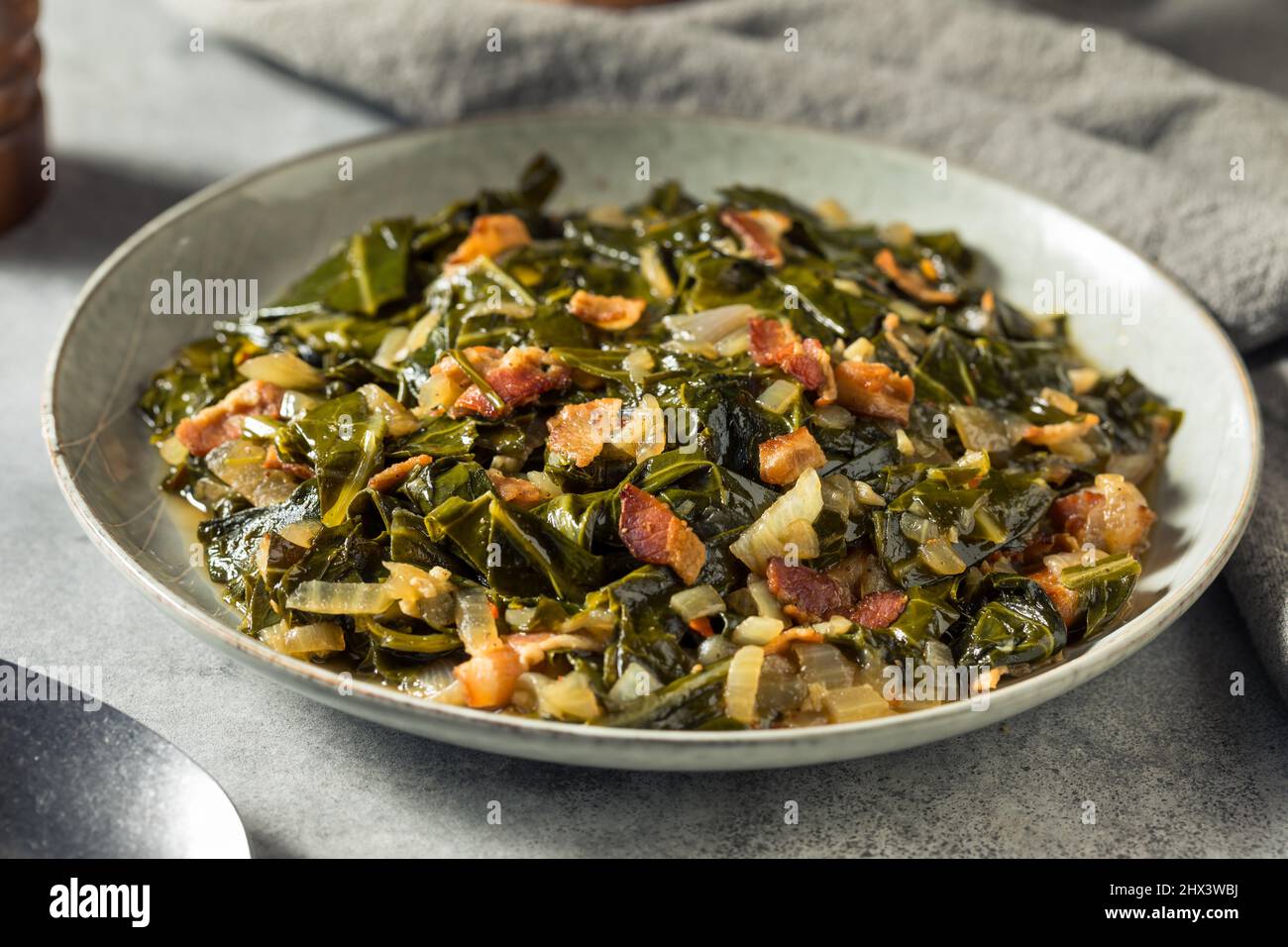 Hausgemachte südliche sautierte Collard Greens mit Zwiebeln und Speck Stockfoto