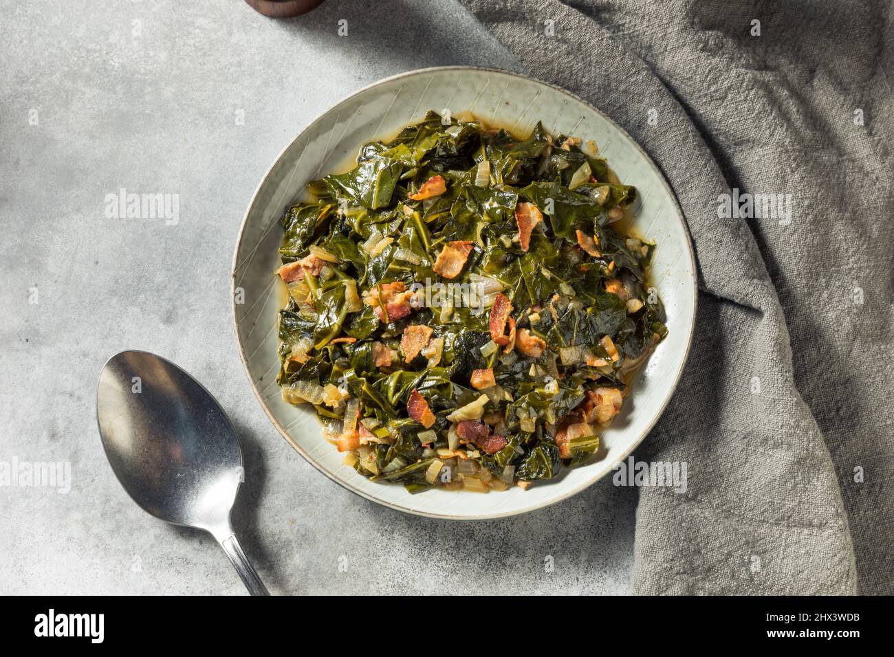 Hausgemachte südliche sautierte Collard Greens mit Zwiebeln und Speck Stockfoto