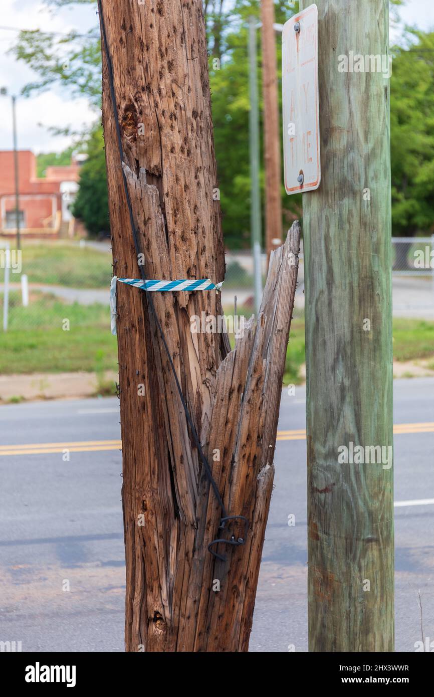 ELKIN, NC, USA-6 JUNE 2021, gebrochener, aber stehender Versorgungsmast, mit Ersatzmast daneben. Stockfoto