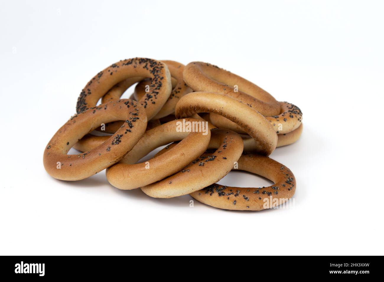 Haufen Bagels mit Mohnsamen isoliert auf weißem Hintergrund, Seitenansicht, Lebensmittelbäckerei-Konzept Stockfoto