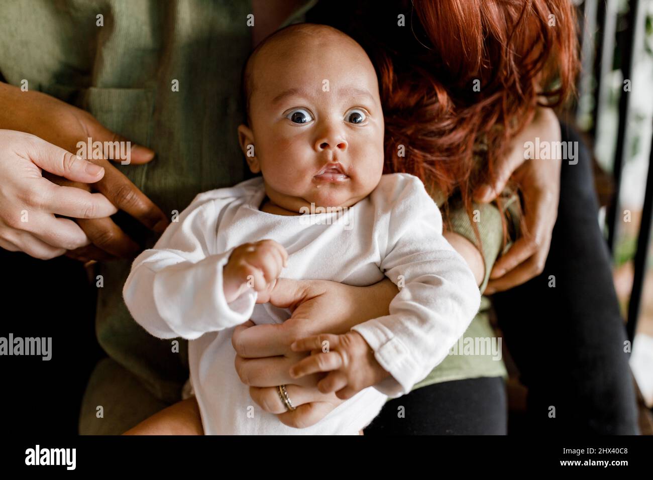 Glücklich afrikanischen jungen Vater sitzen mit kleinen Jungen Sohn Kind, verbringen Zeit mit jungen kaukasischen Frau, küssen Mann, gemischte Rasse Familie mit Kind zu Hause , Stockfoto