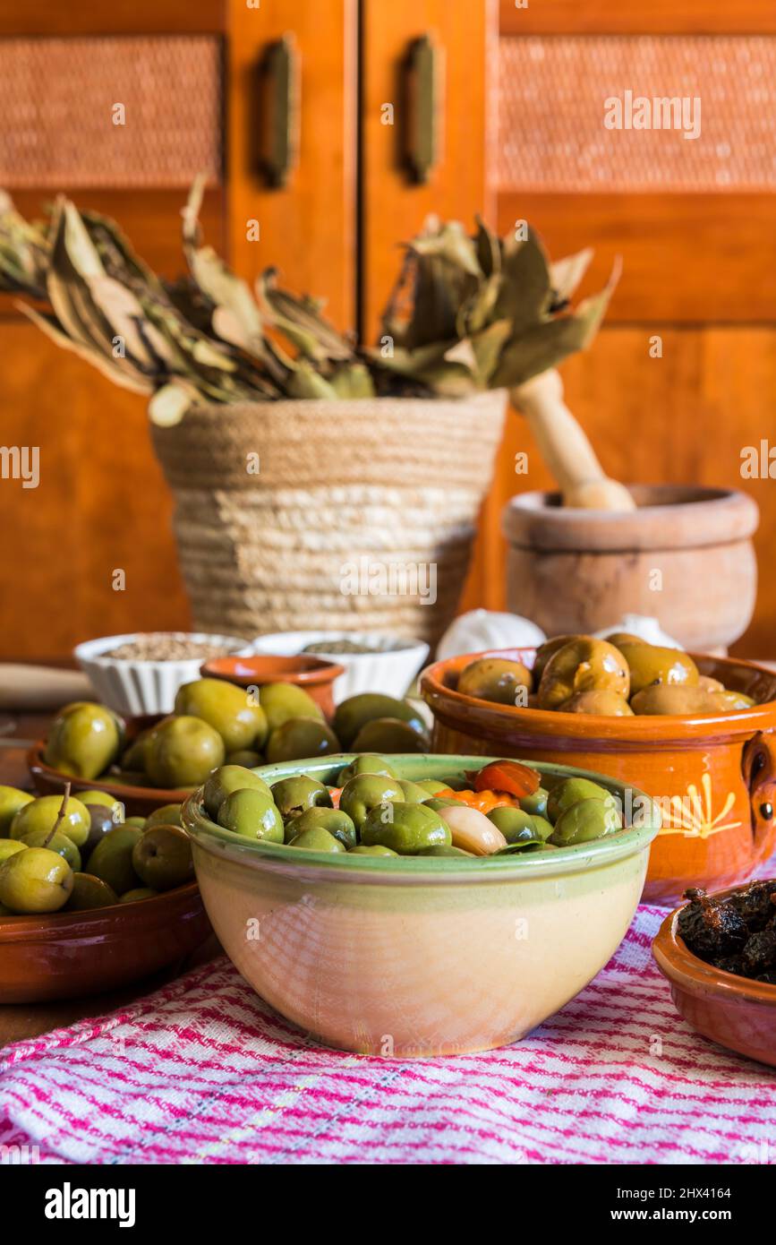 Stillleben mit verschiedenen Olivensorten, präsentiert in Schalen, gekleidet mit verschiedenen traditionellen Dressings. Traditionelle hausgemachte Dressings, typisch Stockfoto