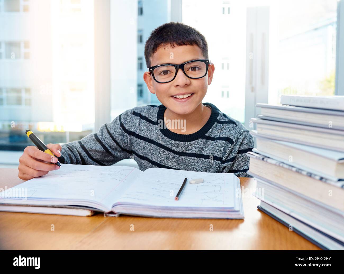 Er weiß bereits, wie wichtig Bildung für seine Zukunft ist. Porträt eines entschlossenen Jungen, der zu Hause seine Hausaufgaben macht. Stockfoto